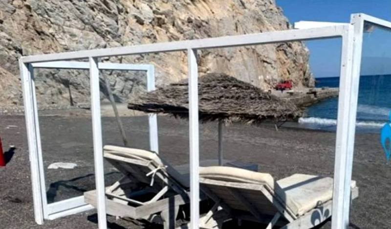 Soluția găsită de o plajă din Grecia pentru protecția turiștilor. Șezlonguri împrejmuite de pereți din pexiglas