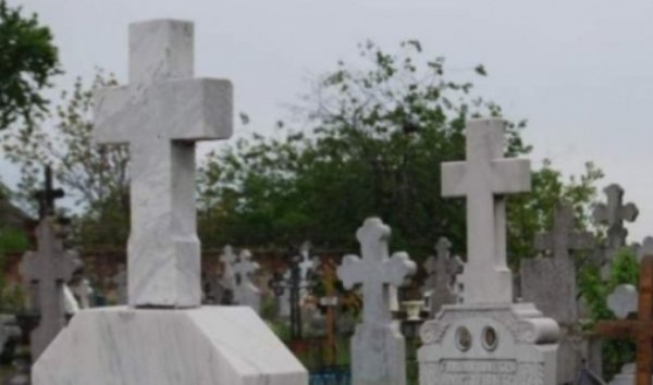 Bărbat găsit mort într-un cimitir, strivit de o cruce. Poliţiştii au deschis dosar pentru moarte suspectă