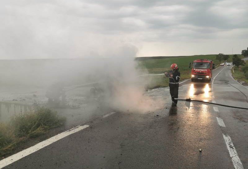 Accident! O mașină a izbit un cap de pod, s-a răsturnat și a luat foc. Doi tineri s-au salvat - FOTO