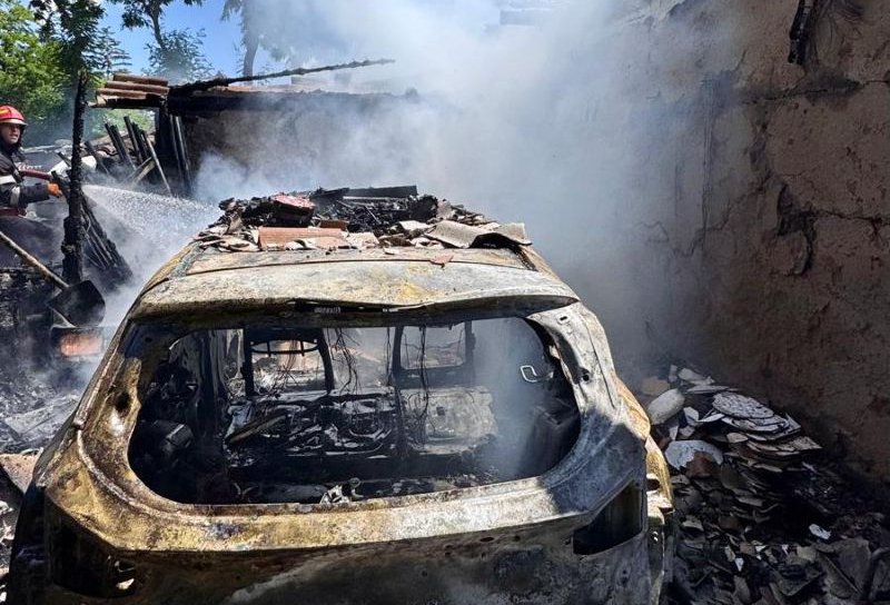Un garaj în care se afla o mașină și mai multe bunuri distruse într-un incendiu violent
